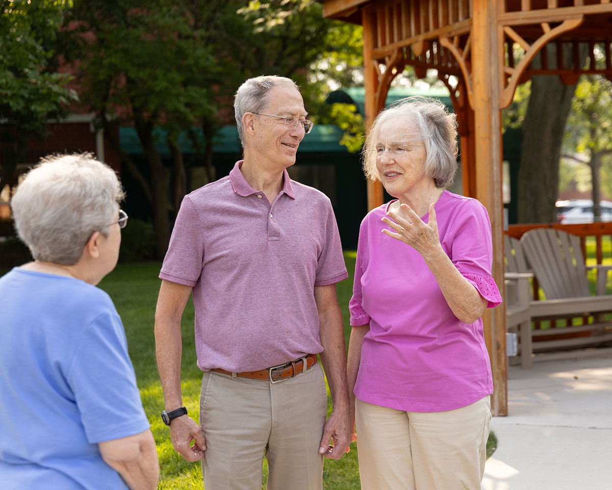 About Our Retirement Community The Moorings Of Arlington Heights   Moorings OC Residents Chatting Near A Gazebo At The Moorings Of Arlington Heights 