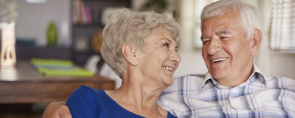 Happy senior couple sitting on sofa