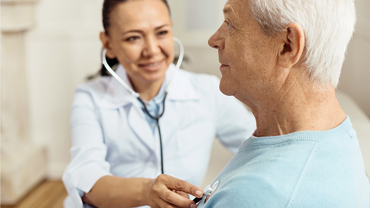 a senior man having his heartbeat monitored by a nurse at his senior living community