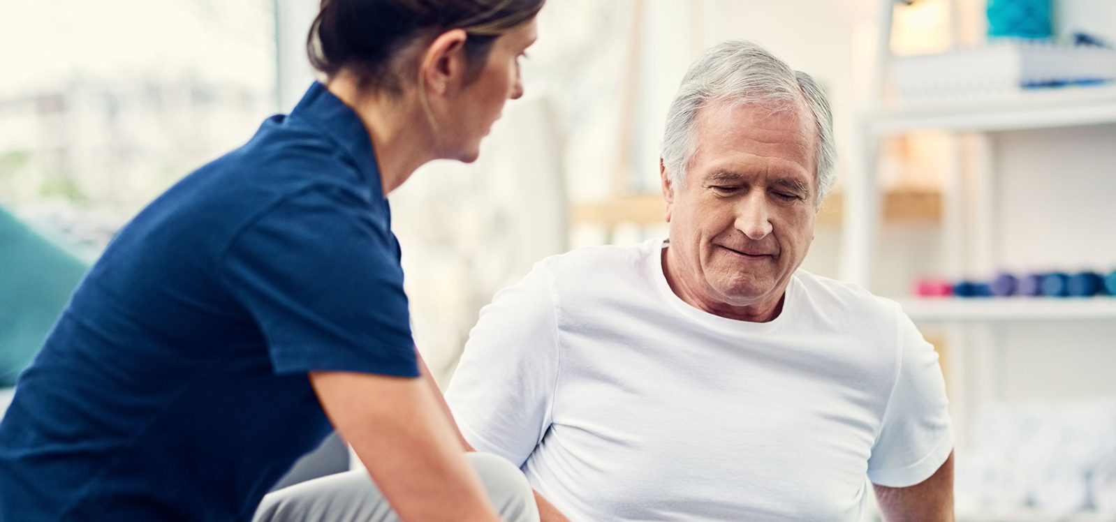 young female physiotherapist working with a senior male patient