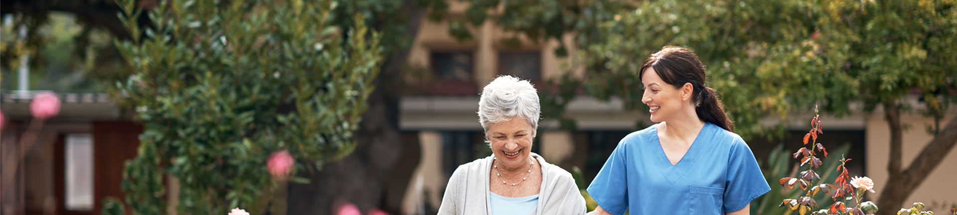 a senior woman and a nurse walking outside