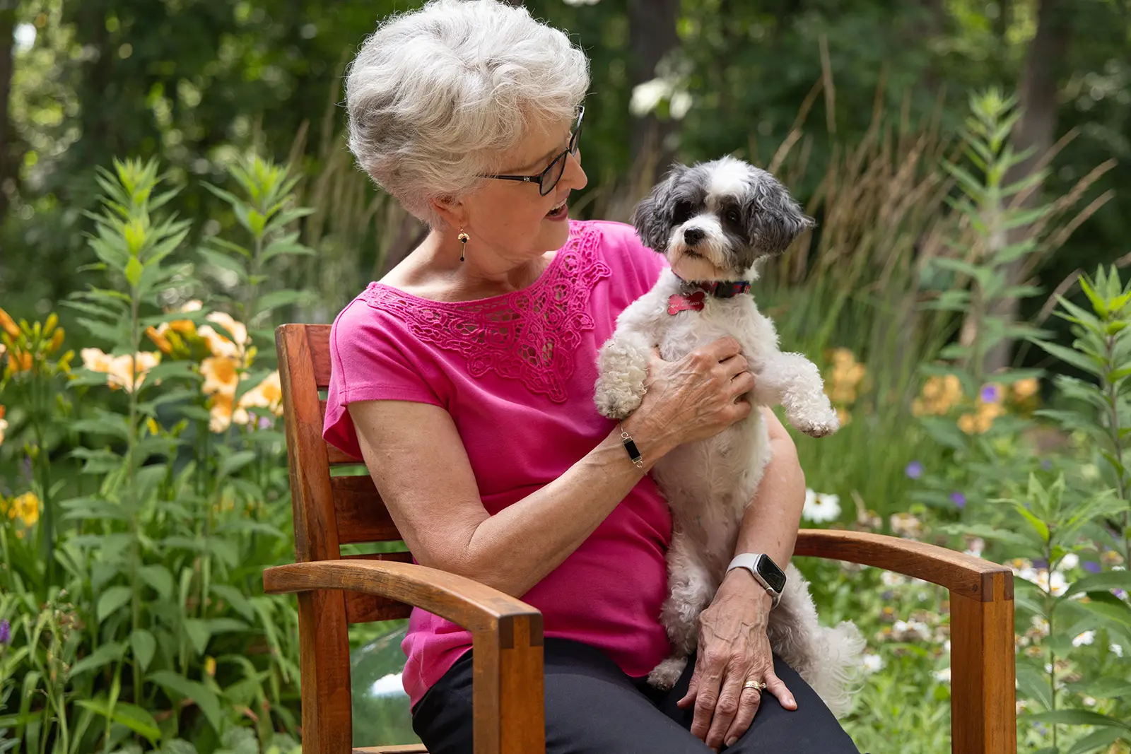 Resident sitting outdoors at Lake Forest Place with her dog