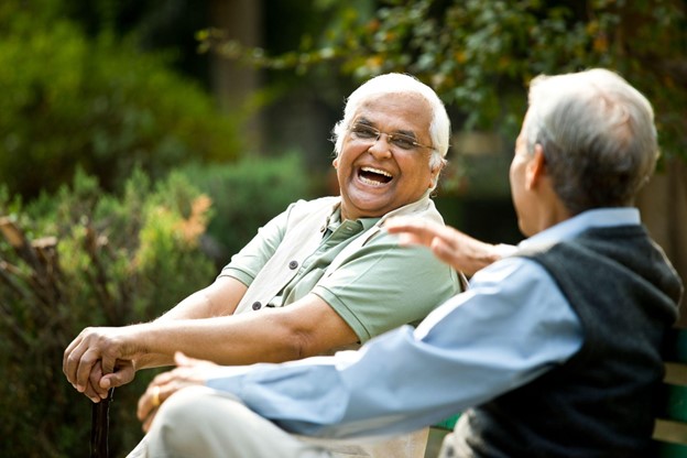 senior men sitting outside laughing together