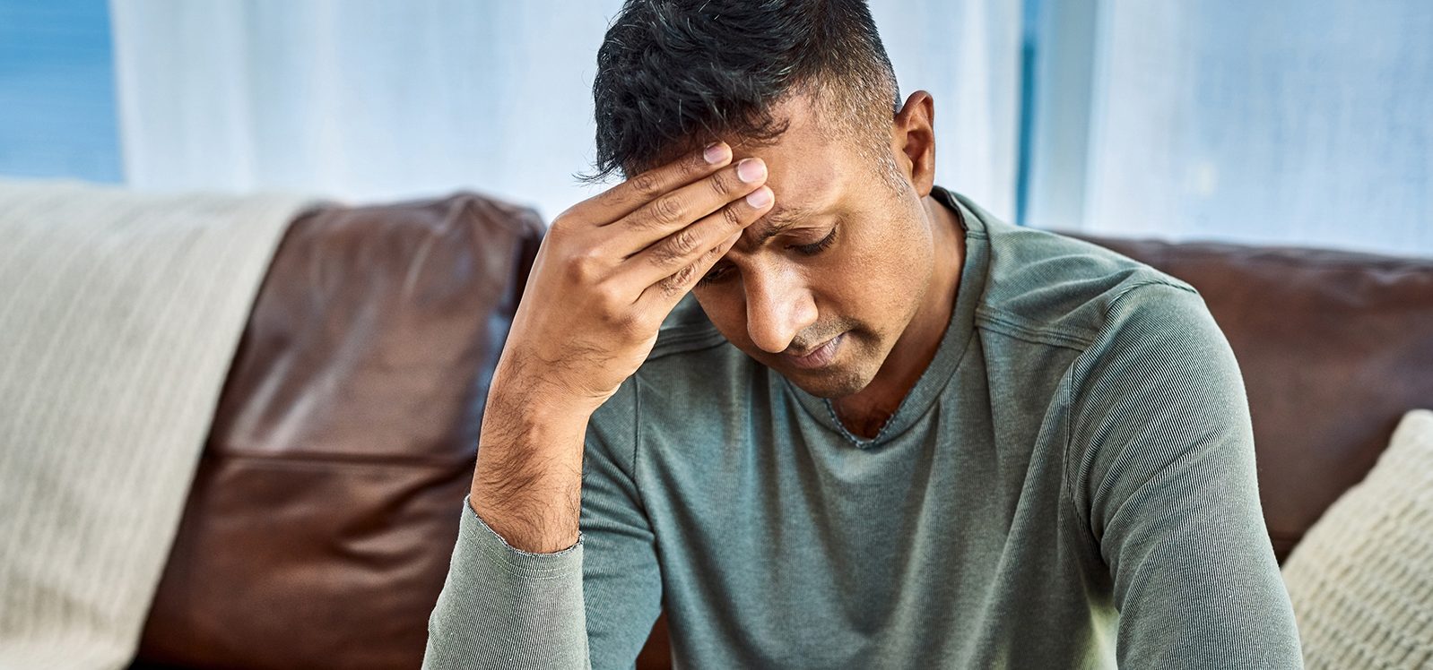 adult child rubbing his forehead looking tired