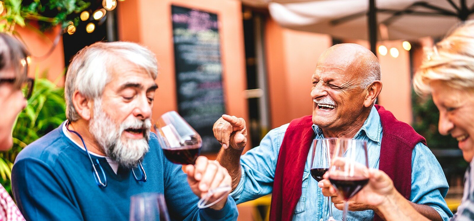 Seniors eating and drinking at a nice restaurant.