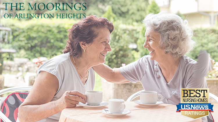 two senior women enjoying cups of coffee at The Moorings of Arlington Heights senior living community