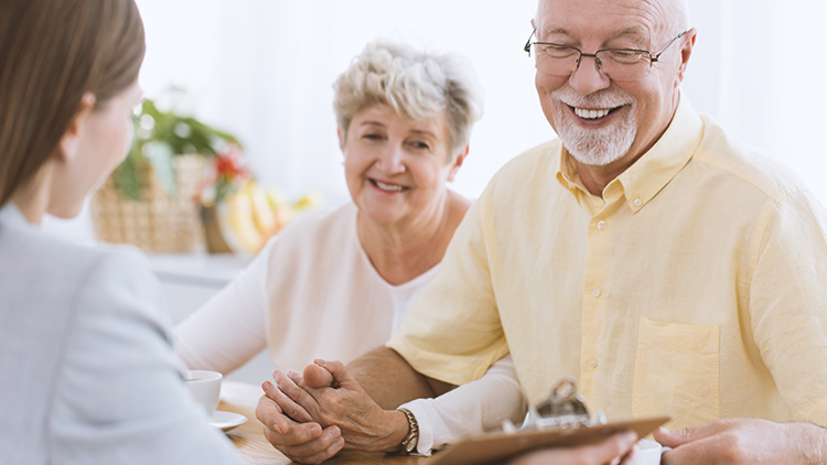 a senior couple meeting with a senior move manager