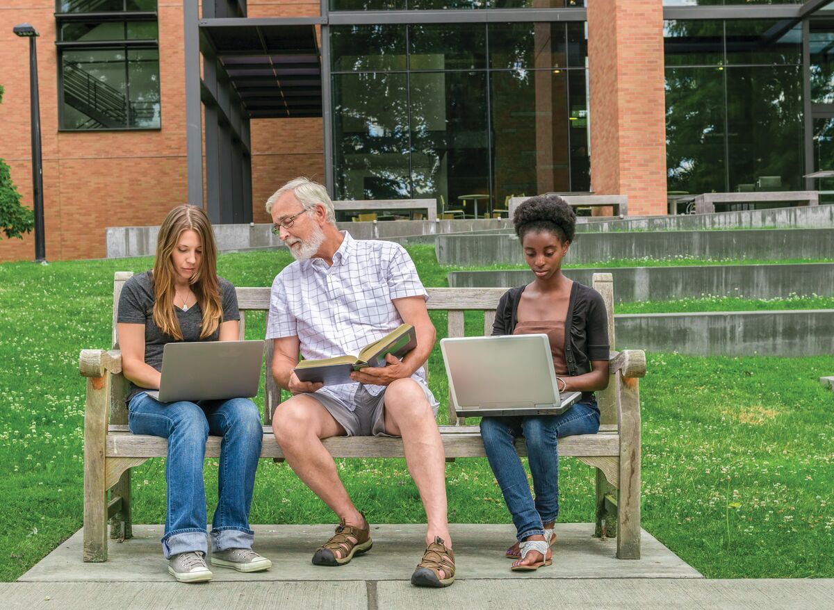 A professor engaging with students at a university campus