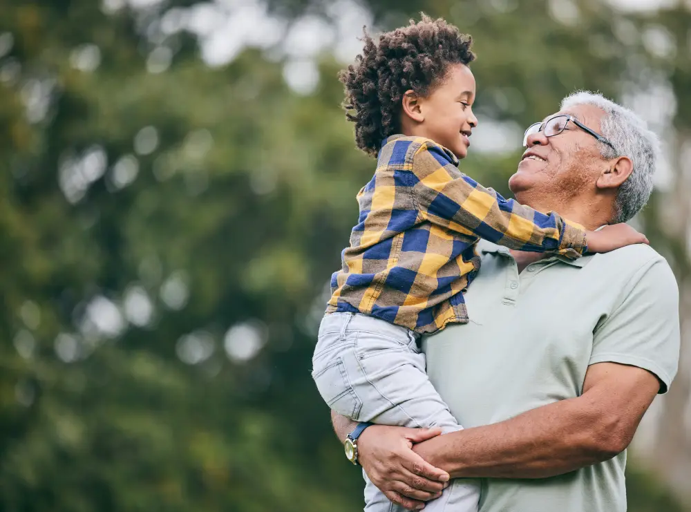 senior man holding his young grandson