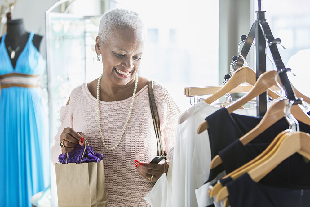 senior woman looking at clothing on a rack