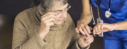 senior woman with anogognosia dementia being helped by her caregiver